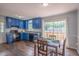 Bright kitchen with blue cabinets, black appliances, and a sliding door to the outdoor deck at 1309 Sweet Charm Ln, Knightdale, NC 27545