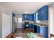 Updated kitchen with blue cabinets, granite countertops, and black appliances providing style and modern convenience at 1309 Sweet Charm Ln, Knightdale, NC 27545