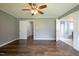 A bright main bedroom features hardwood floors, a ceiling fan, and multiple doors leading to closets and the en suite bathroom at 1309 Sweet Charm Ln, Knightdale, NC 27545