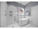 Modern bathroom featuring a glass-enclosed shower and soaking tub with natural light from the window at 1330 Rodessa, Raleigh, NC 27607