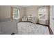 This cozy Bedroom includes a crib, patterned chair, neutral decor, and bright windows at 1330 Rodessa, Raleigh, NC 27607