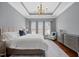 Bright and airy main bedroom with hardwood floors, a cozy chair and an elegant chandelier at 1330 Rodessa, Raleigh, NC 27607