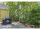 Backyard with a stone path, lush greenery, and a grill at 1405 Pennsylvania Ave, Durham, NC 27705