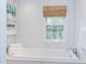 Bright bathroom with a tub, large window, and built-in storage at 1405 Pennsylvania Ave, Durham, NC 27705