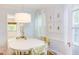 Light-filled dining room with fern prints, white table, and view to the living area at 1405 Pennsylvania Ave, Durham, NC 27705