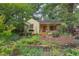 Charming front yard features a quaint cottage-style home, surrounded by a stone wall and colorful flowers at 1405 Pennsylvania Ave, Durham, NC 27705