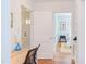 Interior showing a desk area, with view of a bedroom featuring a neat bed and warm lighting at 1405 Pennsylvania Ave, Durham, NC 27705