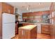Well-equipped kitchen featuring wood cabinetry, stainless steel appliances, and an island at 1405 Pennsylvania Ave, Durham, NC 27705