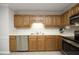 Well-lit kitchen featuring wooden cabinetry, stainless steel appliances, and ample counter space at 146 Greenmont Ln, Cary, NC 27511