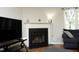 Living room view with fireplace, TV, and a comfortable blue sofa by the window at 146 Greenmont Ln, Cary, NC 27511