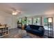 Inviting sunroom with bright windows and comfortable blue sofa surrounded by green plants at 1613 Euclid Rd, Durham, NC 27713