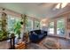 Bright sunroom with many windows, a comfortable blue sofa, and plants at 1613 Euclid Rd, Durham, NC 27713