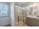 Bathroom showcasing a glass-enclosed shower, a window, and a gray vanity, combining style and functionality at 1624 Tunnel St, Wendell, NC 27591