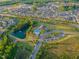 Aerial view of community amenities, including a pool, playground, and pond, nestled among lush greenery at 1624 Tunnel St, Wendell, NC 27591