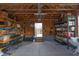 Spacious garage featuring exposed wood, storage shelves and door leading to the exterior of the home at 1624 Tunnel St, Wendell, NC 27591