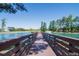 Scenic pond view with a wooden walkway, fountain, and surrounding trees and homes at 1624 Tunnel St, Wendell, NC 27591