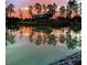 Beautiful sunset reflecting on a tranquil pond surrounded by trees and community buildings at 1624 Tunnel St, Wendell, NC 27591