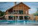 Community pool area with stone clubhouse, water features, patio seating, and green umbrellas at 1624 Tunnel St, Wendell, NC 27591