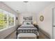 Cozy bedroom featuring neutral walls, a large window and comfortable-looking wrought iron bed frame with storage bench at 1625 Main Divide Dr, Wake Forest, NC 27587