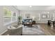 Bright living room featuring hardwood floors, a cozy couch, area rug, and sunlit windows at 1625 Main Divide Dr, Wake Forest, NC 27587