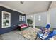 Relaxing covered patio area with cozy seating, colorful outdoor rug and a view of the landscaped backyard at 1625 Main Divide Dr, Wake Forest, NC 27587