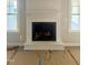 Close-up of a contemporary fireplace with white mantel, flanked by bright windows at 168 Clayton Rd, Princeton, NC 27569