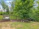 Backyard features a bench, a black metal fence and landscaping at 1804 Amberly Ledge Way, Cary, NC 27519