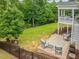 Backyard with brick patio and seating area, deck, landscaped features, and black metal fence at 1804 Amberly Ledge Way, Cary, NC 27519