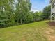 Spacious backyard featuring a lush lawn and a privacy fence surrounded by tall trees at 1804 Amberly Ledge Way, Cary, NC 27519