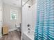 Bright bathroom with a white shower tub and a striped blue curtain at 1804 Amberly Ledge Way, Cary, NC 27519
