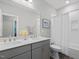 Bright bathroom with a double sink vanity, large mirror and shower with a white shower curtain at 1804 Amberly Ledge Way, Cary, NC 27519