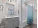 Bathroom with a single sink vanity, gray cabinets, and a shower-tub combo at 1804 Amberly Ledge Way, Cary, NC 27519