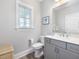 Well-lit bathroom features a gray vanity, white toilet, and a framed blue turtle art print at 1804 Amberly Ledge Way, Cary, NC 27519