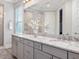 Bathroom featuring a double sink vanity with stone countertop and large mirror and a glass shower at 1804 Amberly Ledge Way, Cary, NC 27519