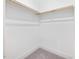 Empty closet with white walls, gray carpet and a simple wooden rod at 1804 Amberly Ledge Way, Cary, NC 27519