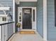 Welcoming front entrance with a classic black door, a 'Welcome' mat, and potted flowers at 1804 Amberly Ledge Way, Cary, NC 27519