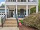Inviting front porch with brick steps, black railing, and charming outdoor seating at 1804 Amberly Ledge Way, Cary, NC 27519