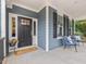 Charming covered front porch with stylish seating and an inviting entryway at 1804 Amberly Ledge Way, Cary, NC 27519