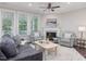Bright living room featuring a cozy fireplace, large windows, and comfortable seating at 1804 Amberly Ledge Way, Cary, NC 27519