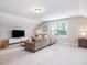 Spacious living area with neutral carpet, a comfortable sofa, and a window offering natural light at 1804 Amberly Ledge Way, Cary, NC 27519
