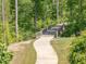 Scenic walking path with a wooden bridge surrounded by lush green trees and foliage at 1804 Amberly Ledge Way, Cary, NC 27519