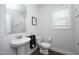 Half bath with white fixtures, dark wood storage shelf, and neutral paint at 200 Sweet Violet Dr, Youngsville, NC 27596