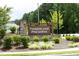 Stone community entrance sign with lush landscaping, creating a welcoming first impression at 200 Sweet Violet Dr, Youngsville, NC 27596