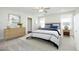 Neutral staged main bedroom with an upholstered headboard, ensuite, and an abundance of natural light at 200 Sweet Violet Dr, Youngsville, NC 27596