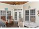 Cozy covered back porch features ceiling fan, rocking chairs and dining table at 2027 Hopeton Ave, Raleigh, NC 27614