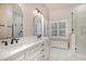 Bright bathroom with double vanity, framed mirrors, and a glass-enclosed shower at 2027 Hopeton Ave, Raleigh, NC 27614