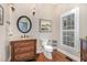 Elegant powder room featuring a decorative vanity, oval mirror, and stylish lighting fixtures in a well-lit space at 2027 Hopeton Ave, Raleigh, NC 27614