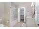 Well-lit bathroom features tub, shower, vanity and walk-in closet at 2027 Hopeton Ave, Raleigh, NC 27614