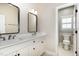 Bathroom with double vanity, modern mirrors, and toilet in a separate area at 2027 Hopeton Ave, Raleigh, NC 27614