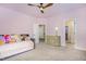 Charming pink bedroom with modern ceiling fan, day bed, and access to full bathroom at 2027 Hopeton Ave, Raleigh, NC 27614
